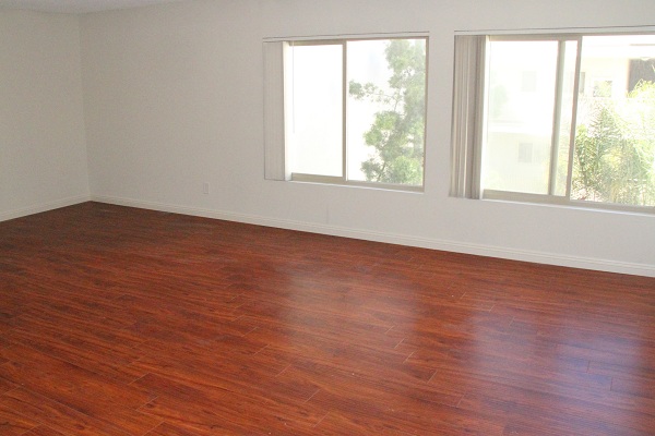 Huge living room with hardwood floor overlooking a beautiful courtyard