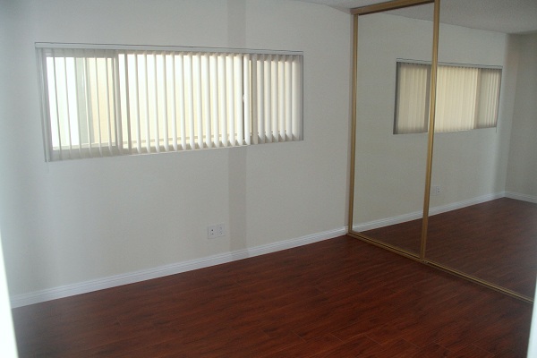 Large Second Bedroom with hardwood floor and wall to wall mirrored closets