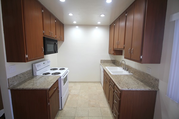 Kitchen with Beautifully Refinished Kitchen Cabinets, Granite Counters and Travertine Floor