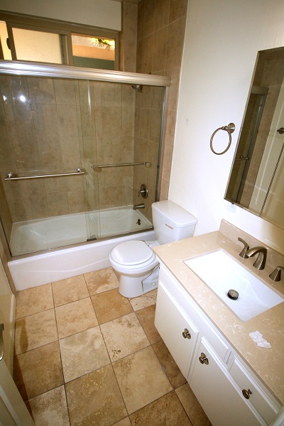Remodeled full bathroom with quartz counter and Travertine floor