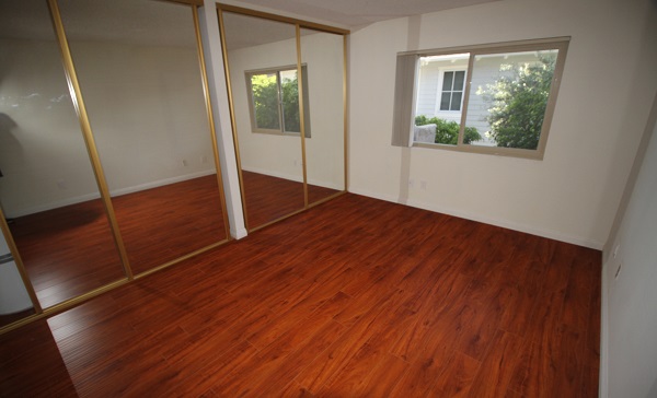 Very Large bedroom with hardwood floors and mirrored closet doors Very Large bedroom with hardwood floors and mirrored closet doors