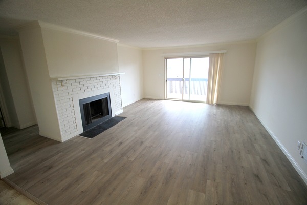 Very large living room with wood burning fireplace opening to large balcony