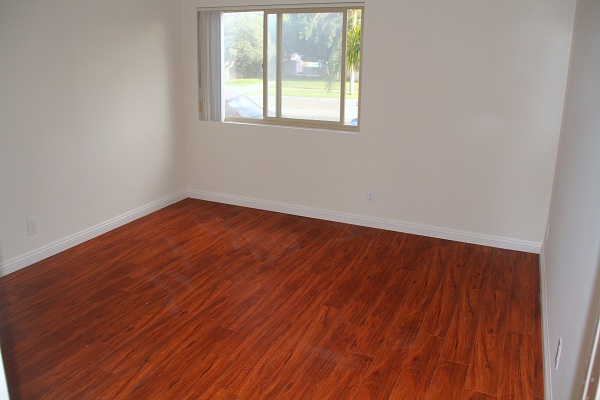 Large Bedroom with hardwood florr and  Mirrored Closet Doors